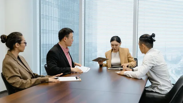 Leader holding a tablet speaking during a boardroom meeting